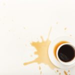 Coffee cup and spilt espresso on white background