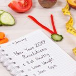 New year resolutions for 2019 and clock made of fresh fruits with vegetables and centimeter